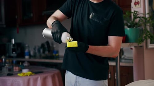 Person Cleaning Couch Cushion with Yellow Sponge