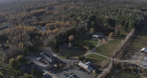 Drone aerial clip of a beautiful acreage property in the fall with a large pond and a bunch of old b