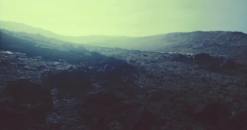Vast Rocky Landscape Under a Soft Greenish Glow at Dawn or Dusk