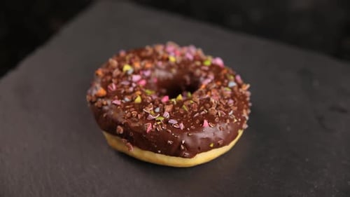Beautiful doughnuts covered in chocolate glaze, sprinkles, marshmallows and chopped nuts