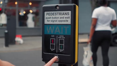 La main appuie sur un bouton sur un feu de circulation en ville