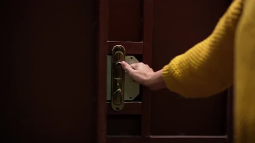 Woman Unlocking a Door Inside a House