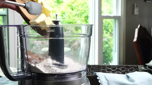 Usar un procesador de alimentos o una licuadora para hacer una masa de postre. Primer plano de la mezcla de ingredientes para hornear con un mapa