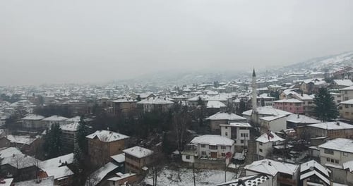 A cinematic drone aerial view of Sarajevo’s Old Town, gently blanketed in fresh snow.