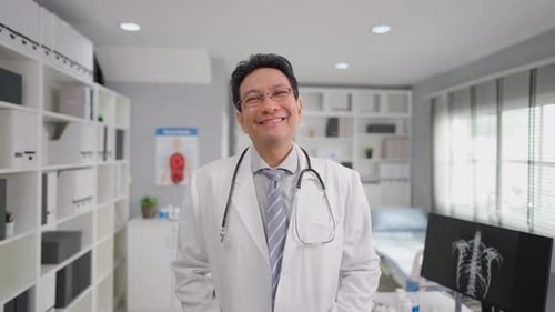 Portrait of Asian mature male doctor standing in a hospital office.