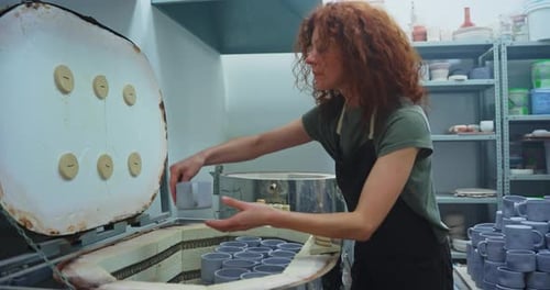 Woman Loading Ceramics into Kiln at Art Studio