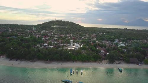Aerial footage of coastline with crystal clear water and boats in Gili Islands