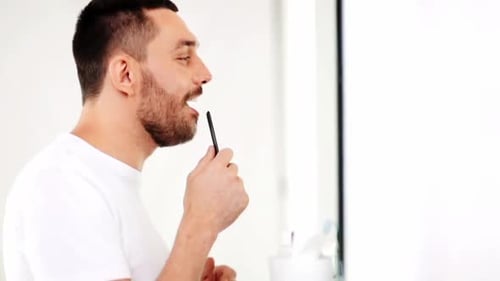 Man styling facial hair with a comb
