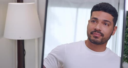 Young Man Grooming Hair and Beard in Mirror