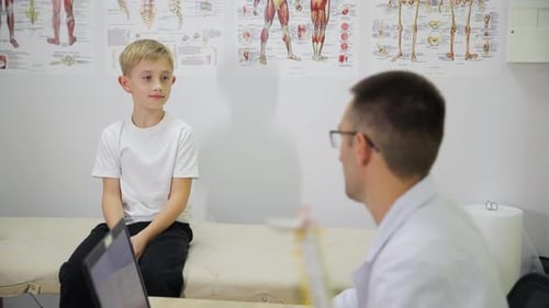 Pediatrician Consulting a Young Boy at Medical Clinic