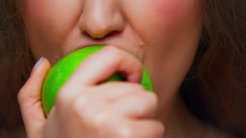 Face Portrait of Young Woman Eating Healthy Food of Green Apple in Closeup Shot