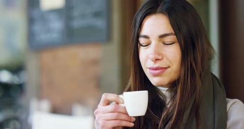 One morning a beautiful elegant woman eats breakfast at the outdoor bar with a coffee and croissan