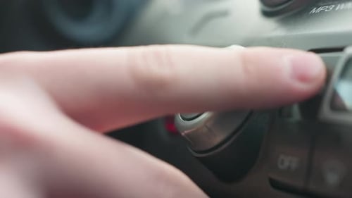 Close Up Finger Turning Ac Knob on Car Climate Control Dial