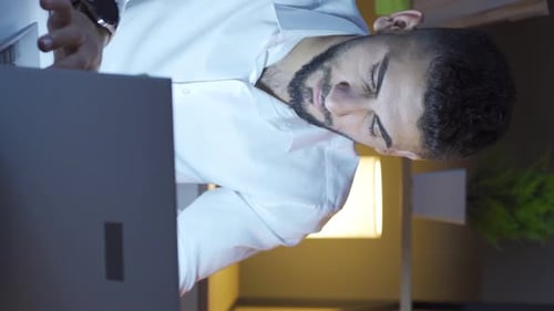 Stressed Man Working Late on Laptop