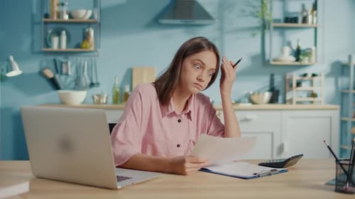 Frustrated Young Woman Accountant Use Calculator to Check Sums in Annual Report