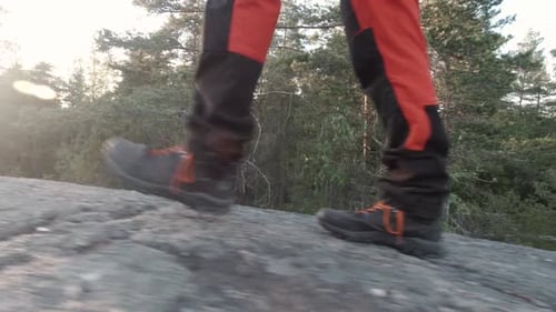 Man walking in the nature during the sunset. Feet close up