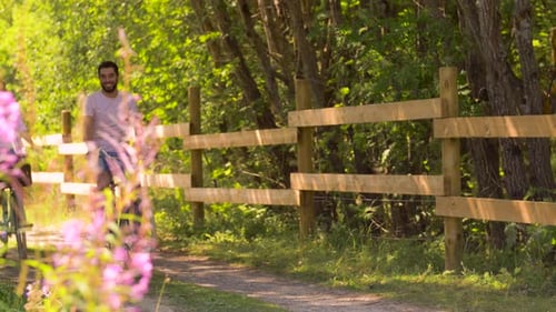 Happy young couple enjoying a bicycle ride together in a sunny summer park