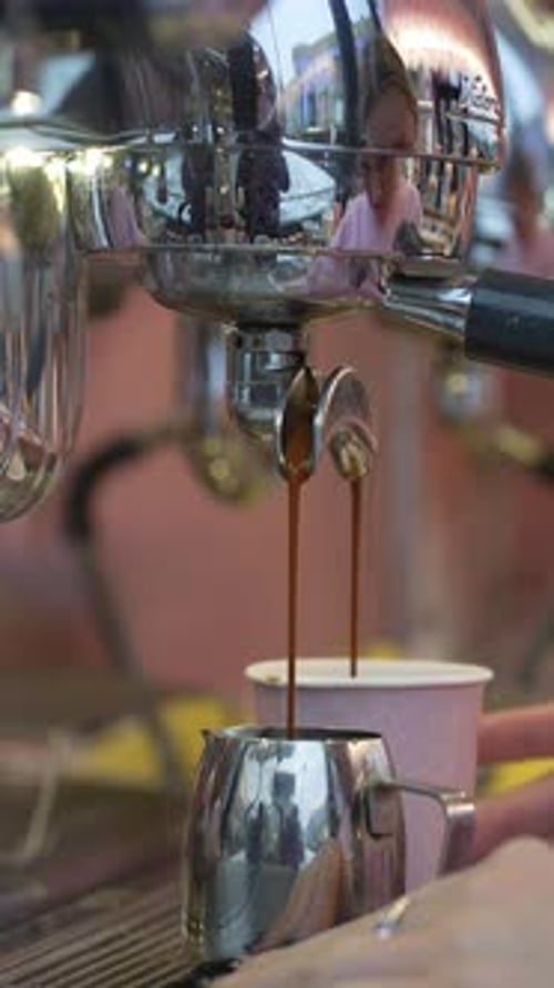 Espresso Pours into Silver Pitcher at Coffee Shop