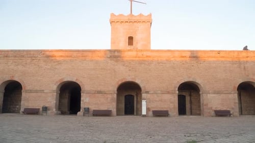 Empty inner courtyard in stone of Montjuic castle wall in Barcelona Spain during sunset with clear