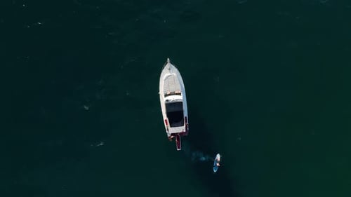 Aerial Drone Tracking Top Down Video of Yacht Cruising in Deep Blue Open Ocean Sea