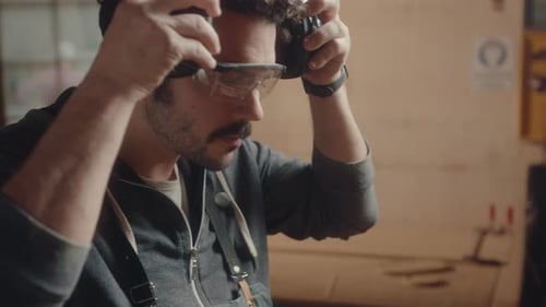 Man Puts on Safety Gear Before Woodworking