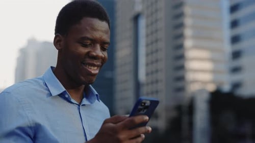 Smiling Man Using Smartphone in Urban Setting
