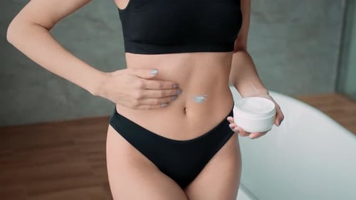 Frau, die tagsüber in einer modernen Innenumgebung Creme aufträgt, mit hochwertigem Filmmaterial