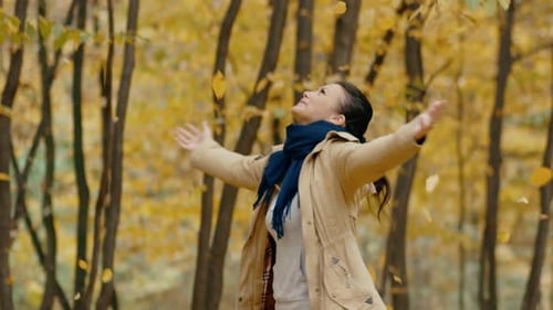 A Cute Girl Has Fun and Enjoys the Beauty of Autumn Leaves and Spins in the Park