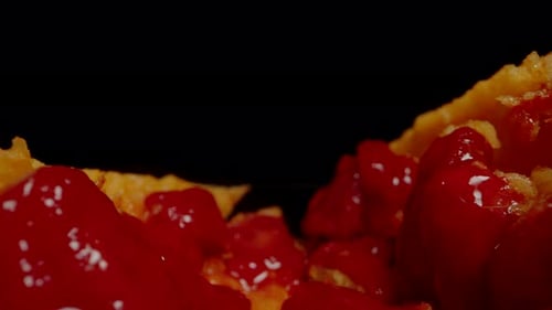 Le melon amer s'ouvre en deux, révélant des graines rouge vif et un intérieur jaune, positionné sur un fond foncé