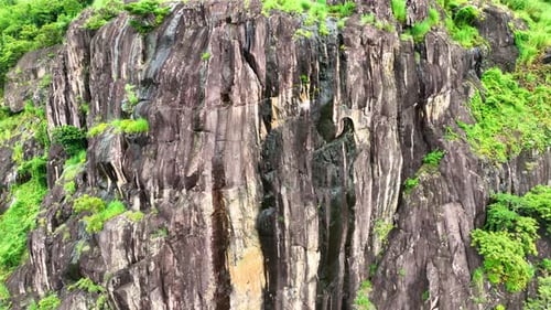 The rocky cliffs are surrounded by a tropical green rainforest. Drone view.