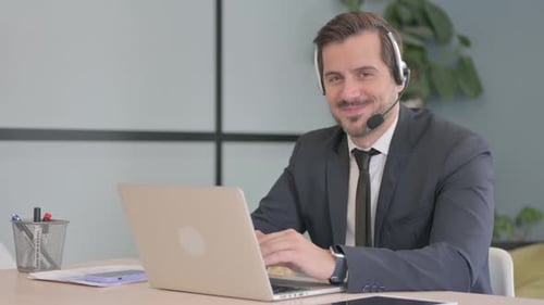 Businessman with Headset Smiling at Camera in Call Center