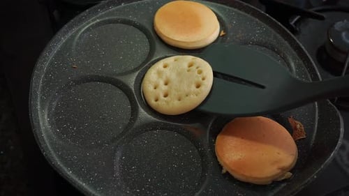 Hausgemachte Pfannkuchen werden mit einem Spatel gedreht