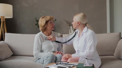 Doctor Listens to Senior Woman's Heart with Stethoscope
