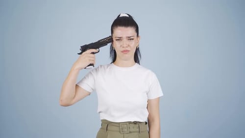 Die Frau mit der Pistole am Kopf ist deprimiert und unglücklich.