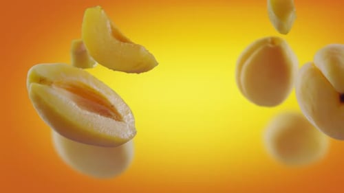 Flying Apricot and Apricots Slices in Orange Background