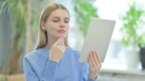 Woman Indoors Using Tablet with Plants in Background