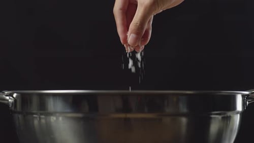 Close Up Of Chef's Hand Adding Salt In The Soup Pot. Sukiyaki Or Shabu In A Pot