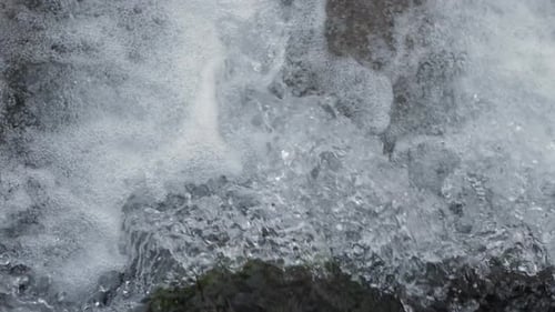 Close-up waterfall, water falling and bubbling slow motion