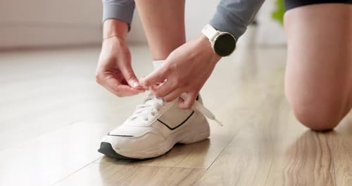 Exercise, hands and tie shoes in gym to start workout, training or fitness