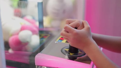 Closeup of Hands Playing Joystick Control on Arcade Claw Machine