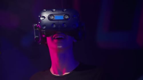 Boy playing VR games in a studio with blue pink neon lights