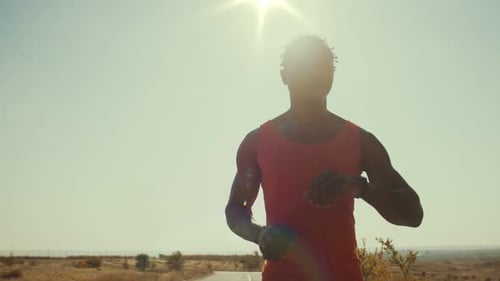 Man Jogging on Rural Road in Bright Sunlight