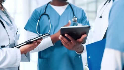 Medical Professionals Discussing Information on Tablet