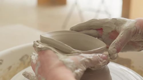 Close Up of Hands Gently Shaping Clay on a Spinning Potter s Wheel
