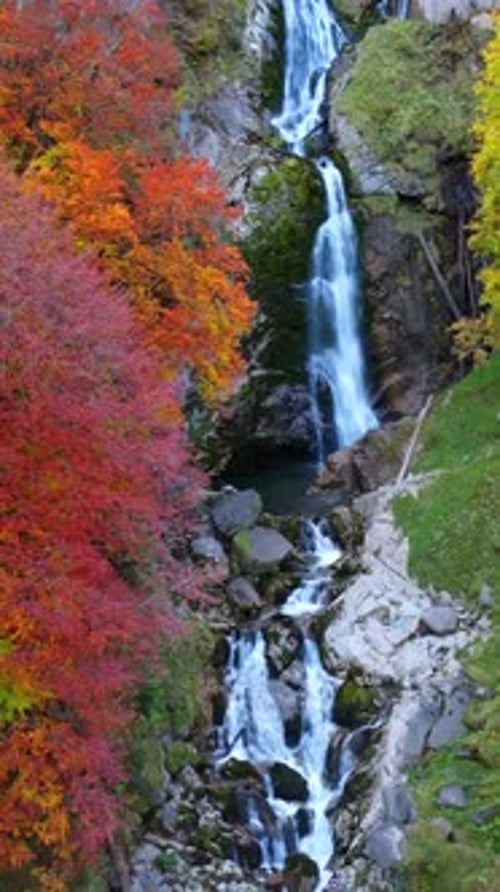 Uma cachoeira impressionante e majestosa, elegantemente cercada por uma folhagem de outono vibrante e colorida