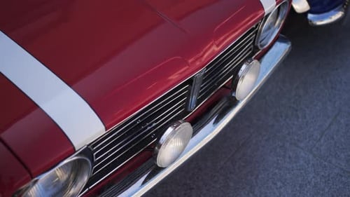 Close-up of classic red vintage car with white racing stripes