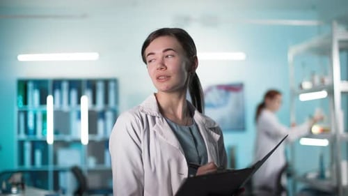 Scientist Writing on Clipboard in Bright Laboratory