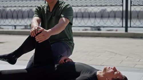 Man Receiving Leg Massage Outdoors on Sunny Day