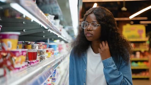 African American Woman Choosing Yogurt in Supermarket