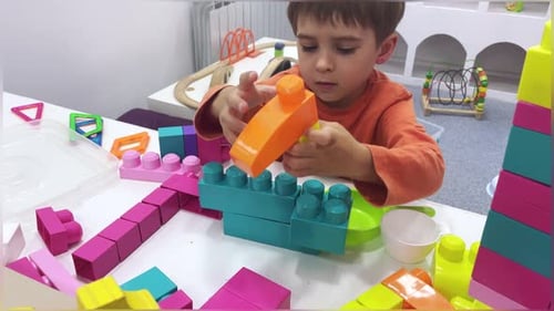 Young Boy Building with Colorful Blocks at Play Table